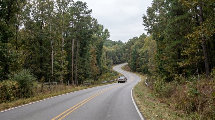 Rural Arkansas road with curves and narrow shoulders representing real driving conditions tested on the Arkansas permit test